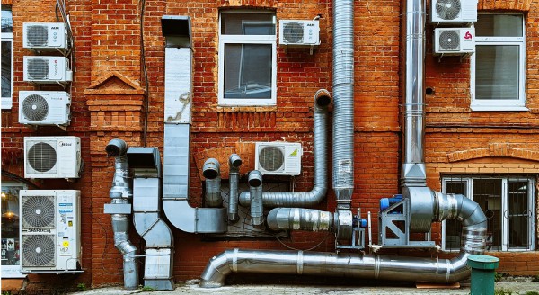 A collection of ducts and vents on a brick wall