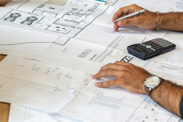 Architect looking over house plans to ensure building code compliance.